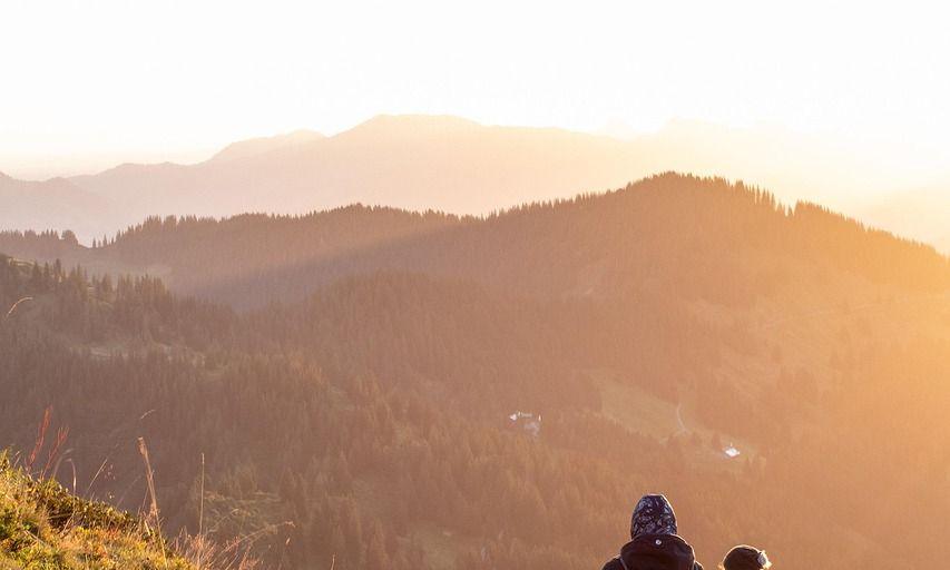 Two hikers walking uphill at sunrise