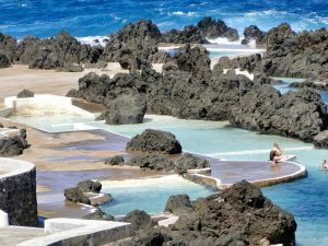 Scenic view of volcanic pools and rocky coastline in Porto Moniz, Madeira.