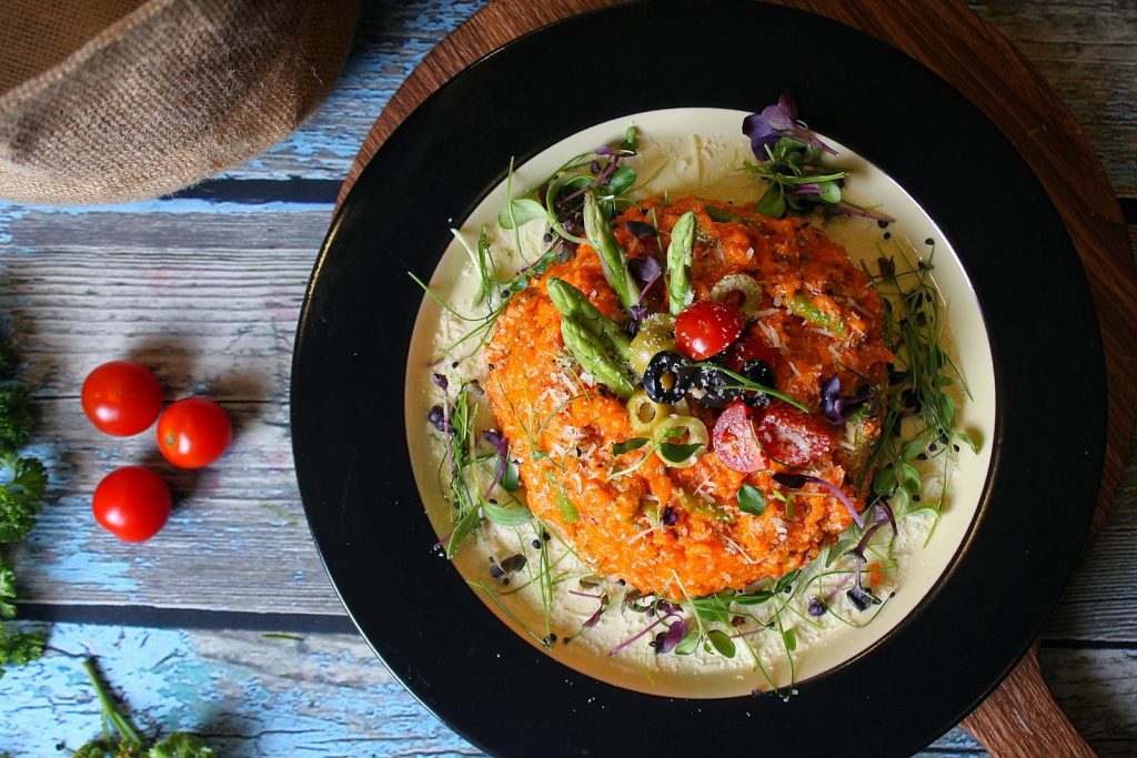 Delicious vegetable risotto presented beautifully with fresh garnishes on a rustic wooden table.